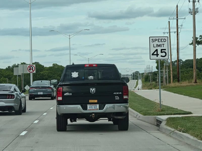 Black pickup truck on road with speed limit sign of 45 mph.