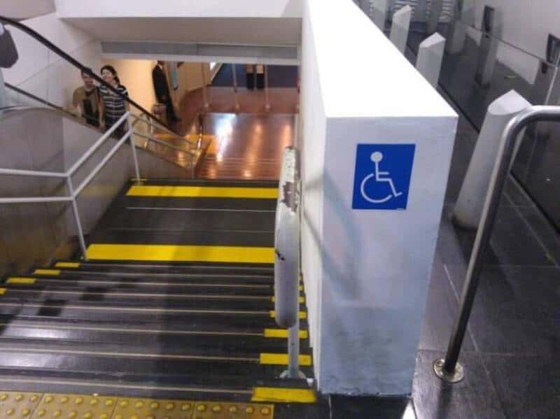 Staircase with yellow markings and a wheelchair sign at the top.