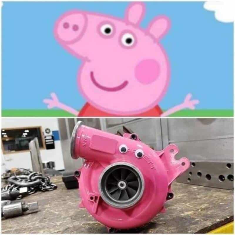 Peppa Pig's head on a pink turbocharger in a workshop.