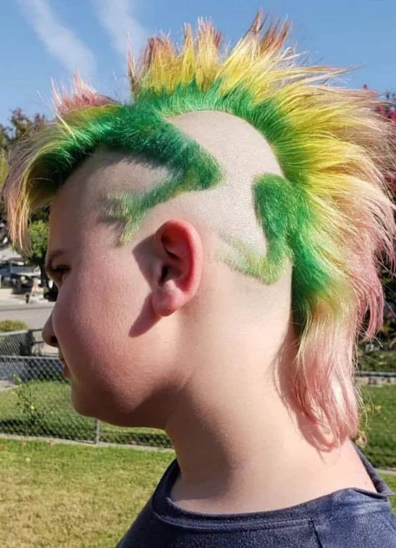 Colorful mohawk hairstyle with green, yellow, and pink spikes on a person's head.