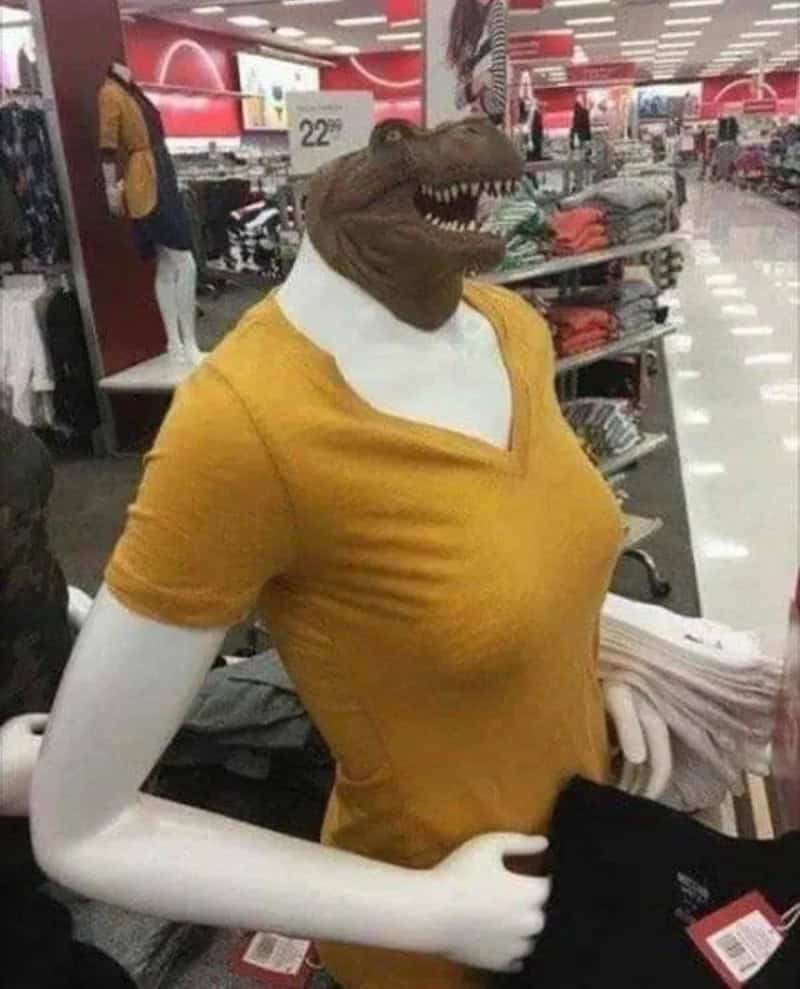 Alligator head mask on a mannequin with a yellow shirt in a retail store.