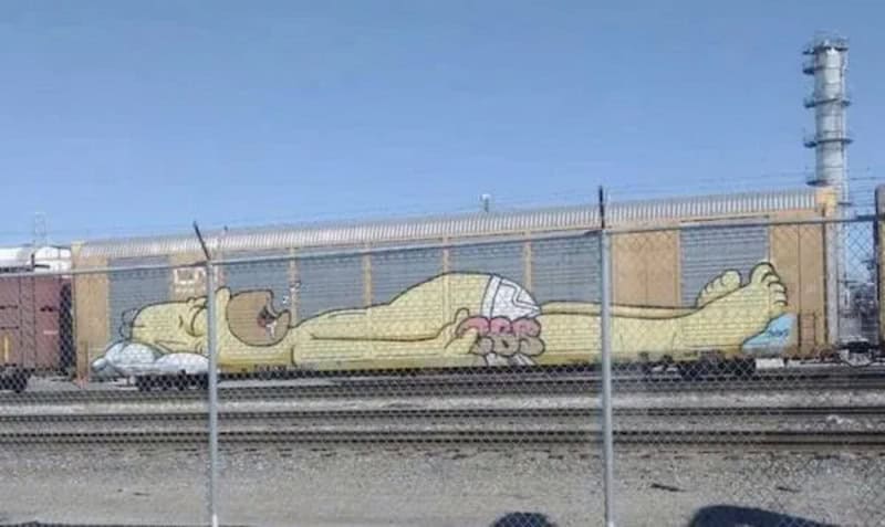 A woman lying on her back with her arms and legs stretched out, painted on a building wall.