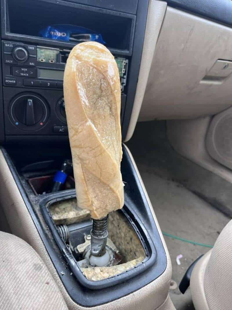 Car gear shift covered with a large piece of bread in the vehicle interior.