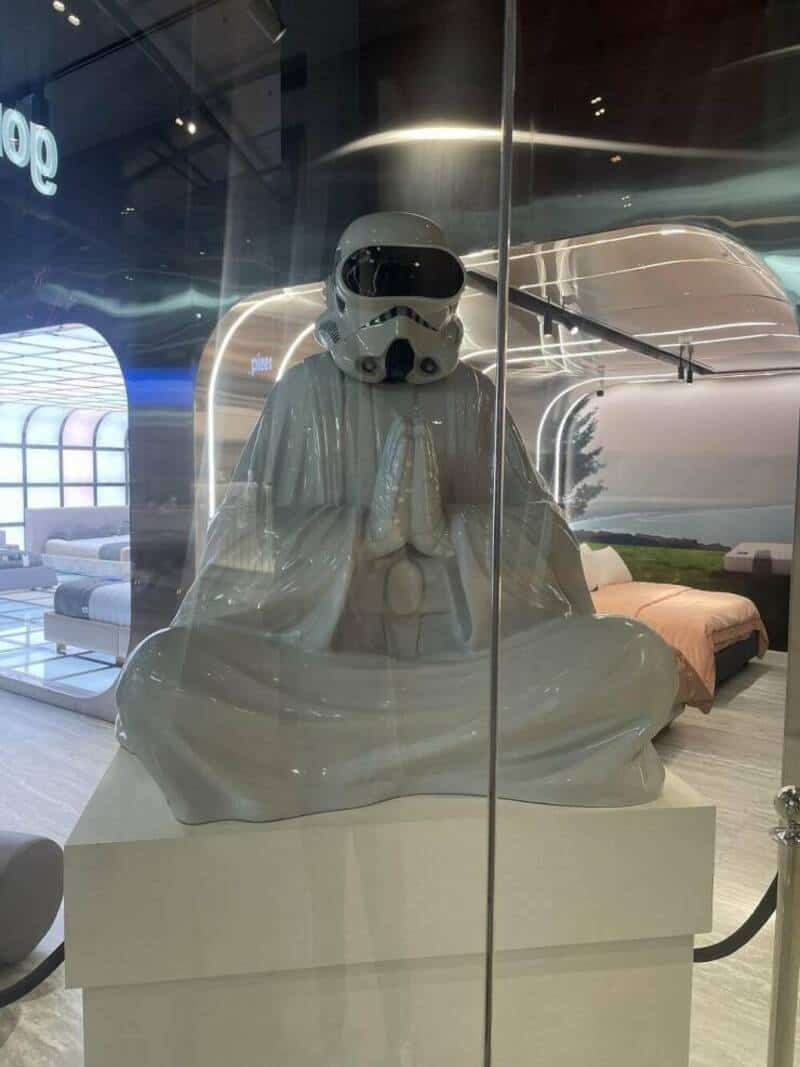 Star Wars Stormtrooper in meditation pose, sitting cross-legged with hands in prayer position inside.