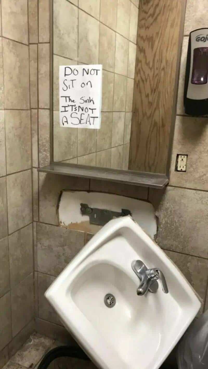 Do not sit on the sink sign in a bathroom, warning not to use the sink as a seat.
