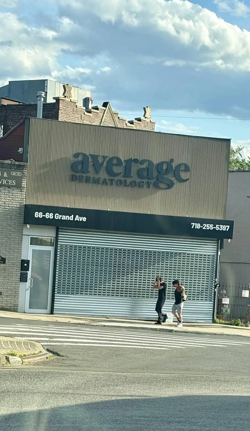 Average Dermatology storefront with two people walking past, located at 66-68 Grand Ave, phone 718-2.