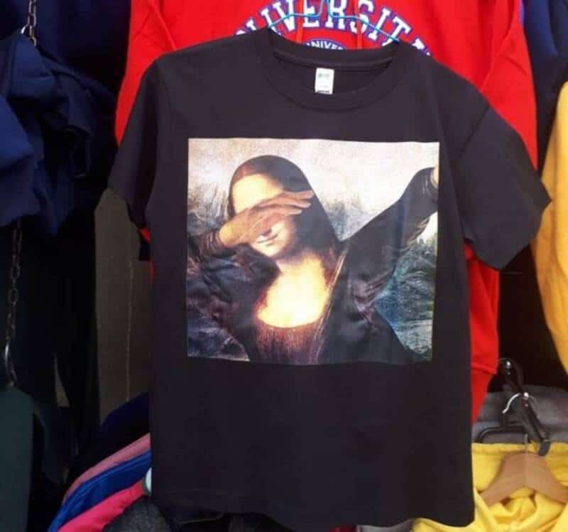 T-shirt with Mona Lisa image and hand covering her eyes, displayed among other clothing items.