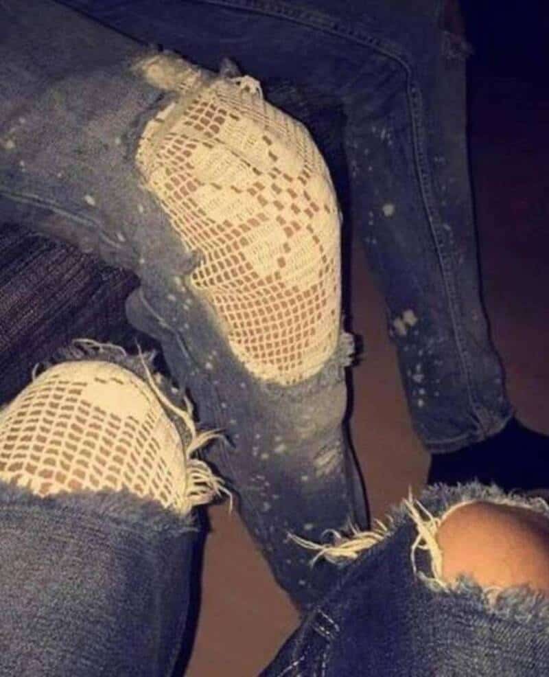 Ripped jeans with fishnet patches and distressed details.