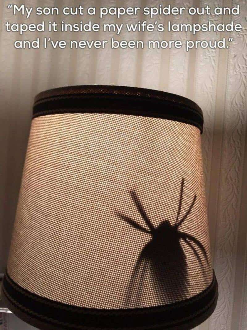 A boy's son cut a paper spider and taped it inside a lampshade.