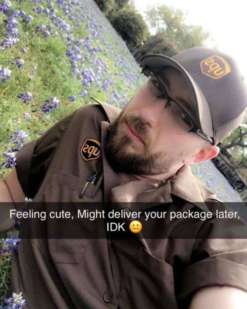 Delivery person in uniform with LSU logo, outdoors with purple flowers background.