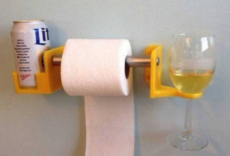 Litter box toilet paper holder with a can of beer and a glass of white wine.