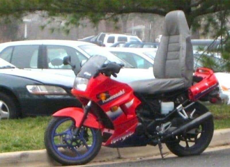 Kawasaki motorcycle with a large, high-back seat in a parking lot.