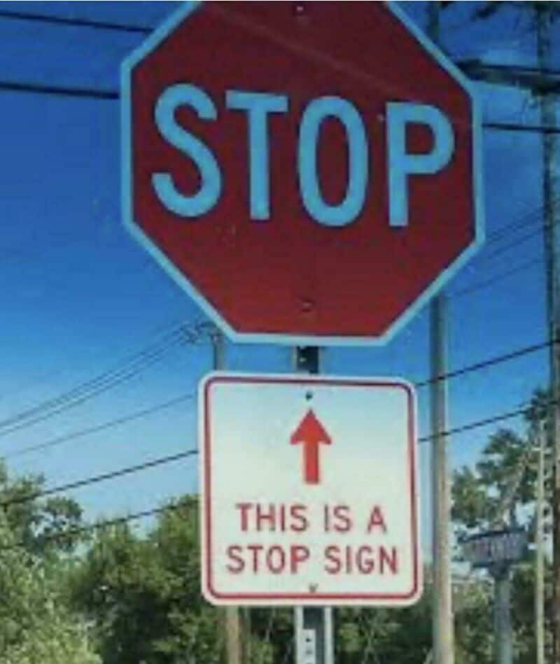 STOP sign with an additional sign below stating "THIS IS A STOP SIGN" in red text.