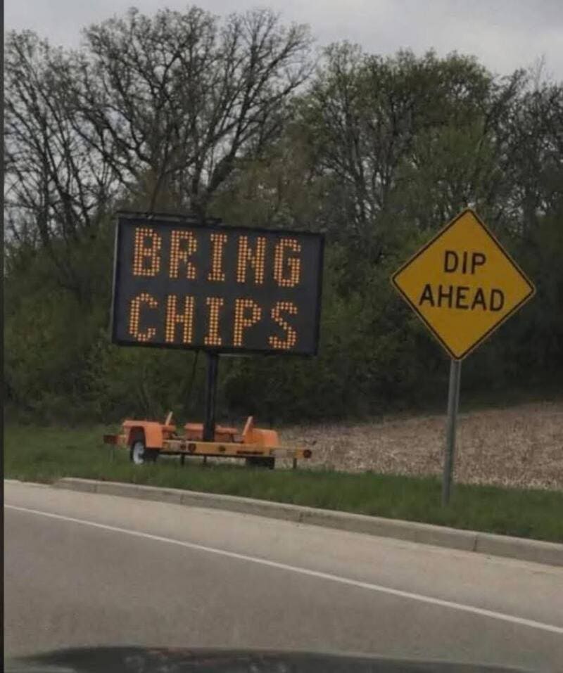 Bring chips sign and dip ahead warning sign on roadside.