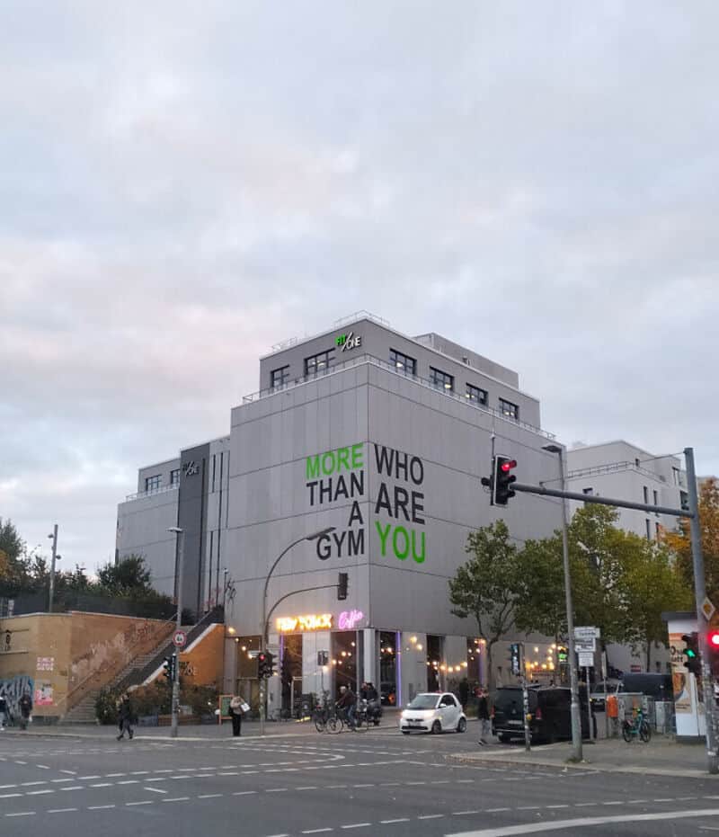 Building with sign reading "More Than a Gym Who Are You" on the side.