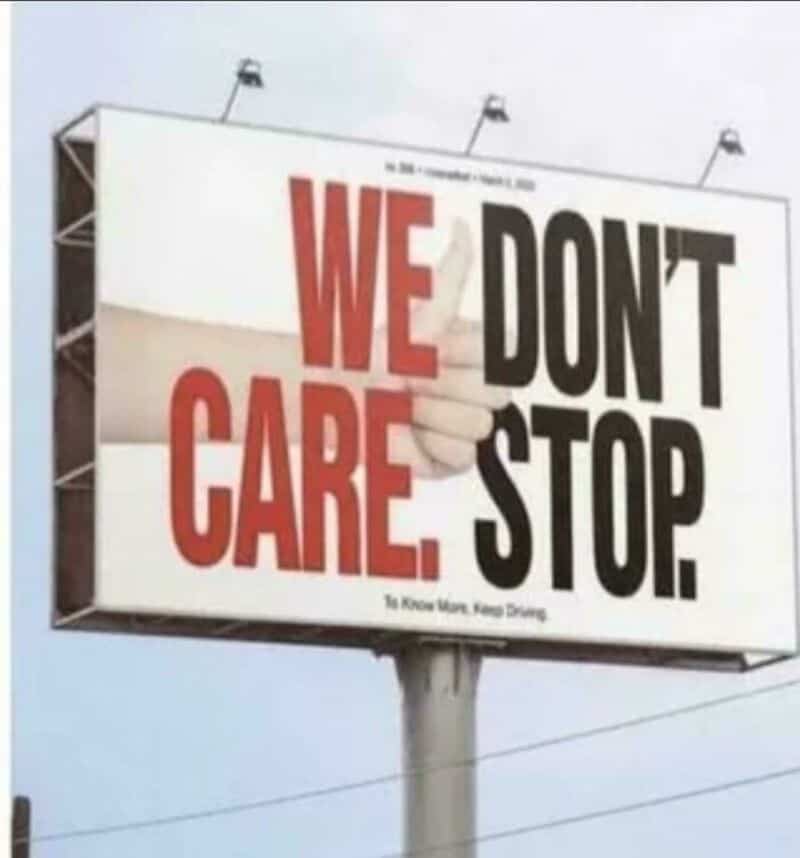 Billboard with text 'WE CARE. WE DON'T STOP.' and a hand pointing to the right.
