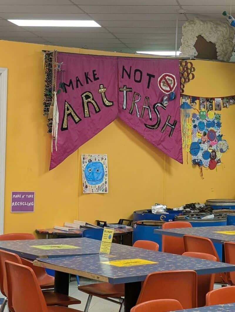 Make Not Art Trash banner in a classroom with colorful decorations and tables.