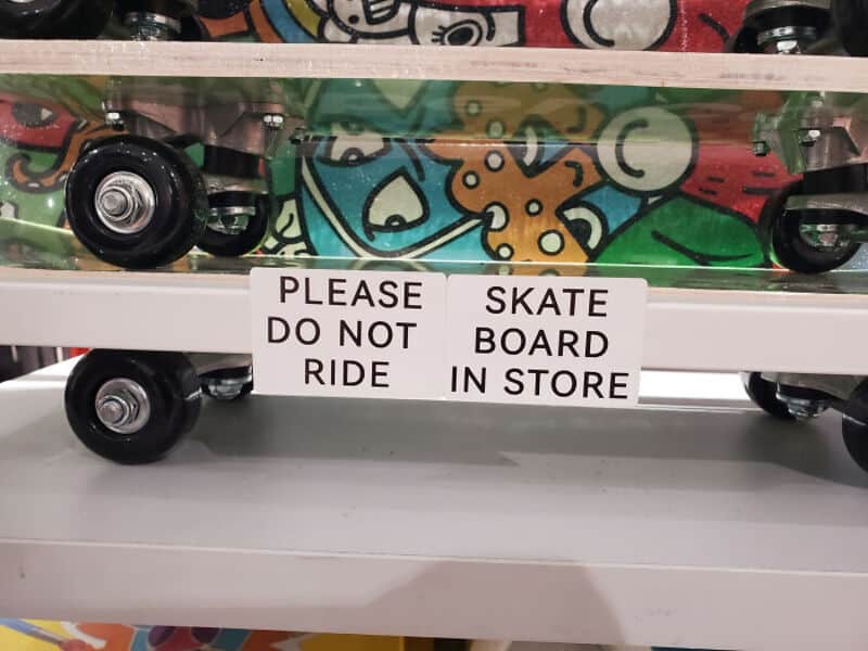 Sign says 'Please do not ride skate board in store'.