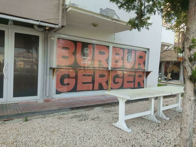 Sign with the words 'BURGER' and 'BURGER' in large letters, with a smaller sign that says 'SMASH & R.