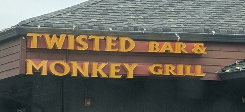 Sign reads 'Twisted Bar & Monkey Grill' in yellow and red letters.