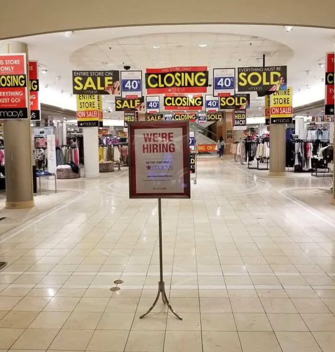Sign in mall: We're hiring, store closing, sale, sold, and on sale signs.