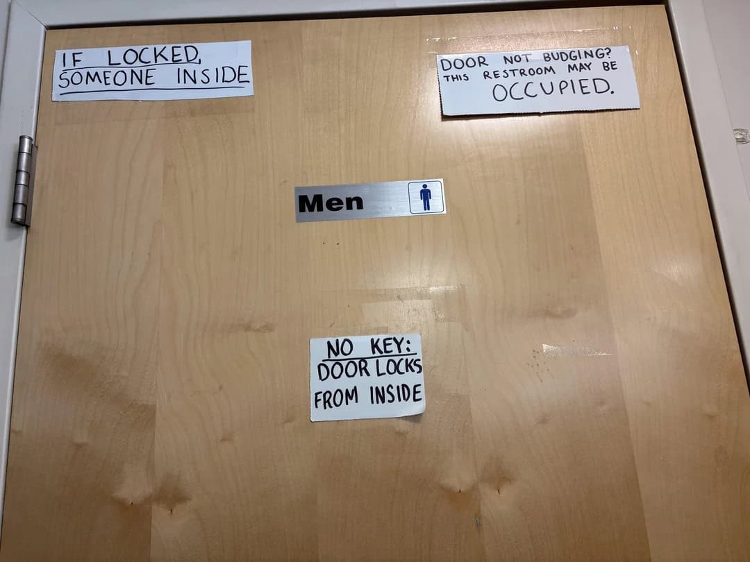 Signs on a door say: 'If locked, someone inside,' 'Door not budging, this restroom may be occupied,'.