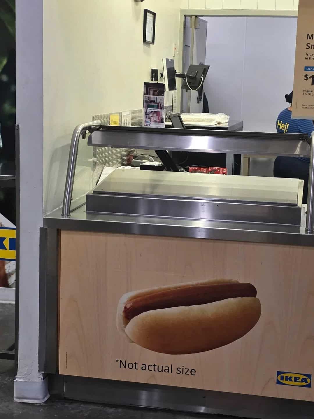 IKEA hot dog stand with a sign saying 'Not actual size' and a hot dog image.