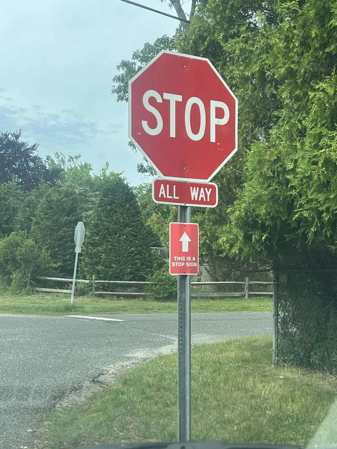 Stop sign with an 'All Way' and 'This is a stop sign' sign below it.