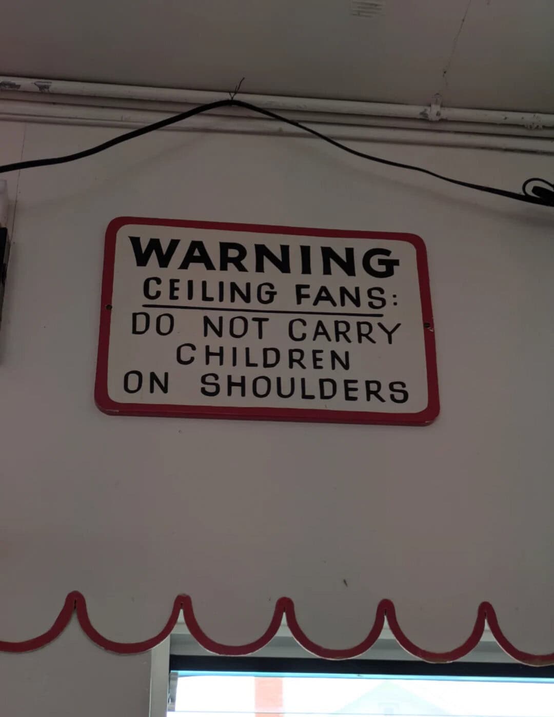 Warning ceiling fans do not carry children on shoulders sign.