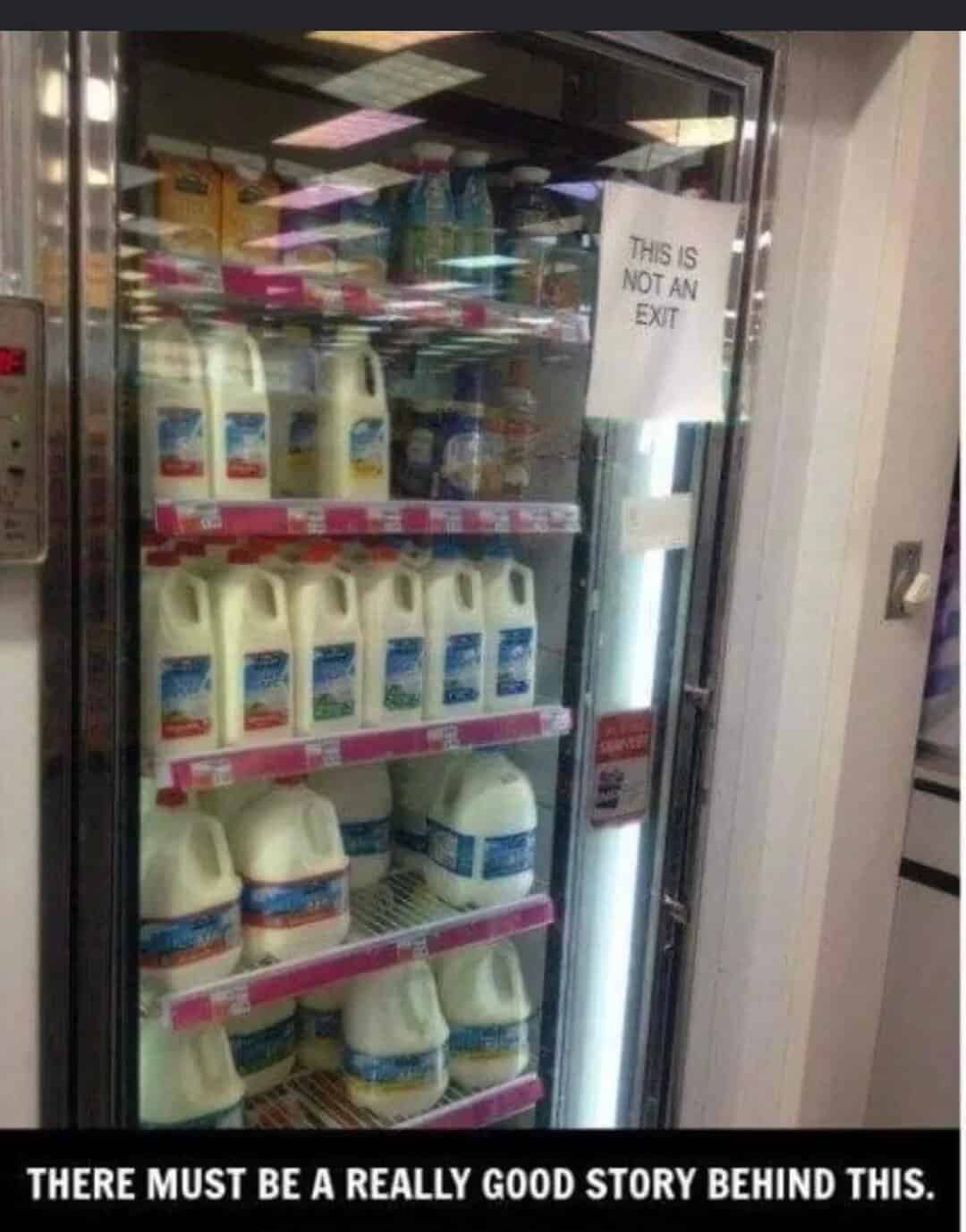 Refrigerator with milk bottles and a sign that says 'This is not an exit'.
