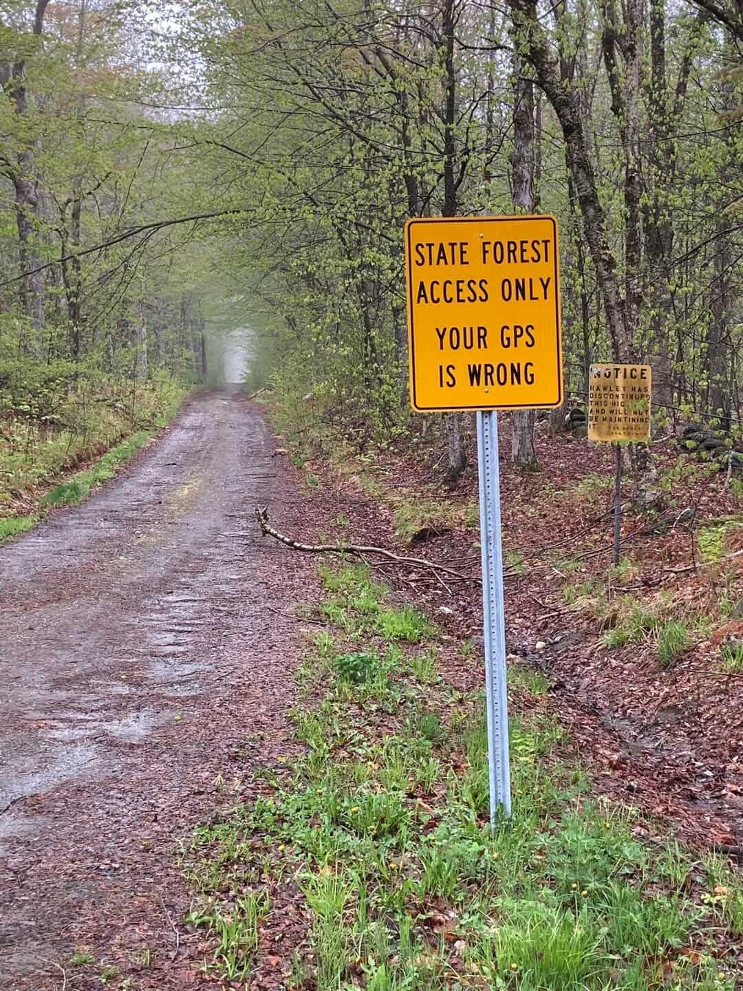 State forest access only, your GPS is wrong sign on a dirt path in a forest.