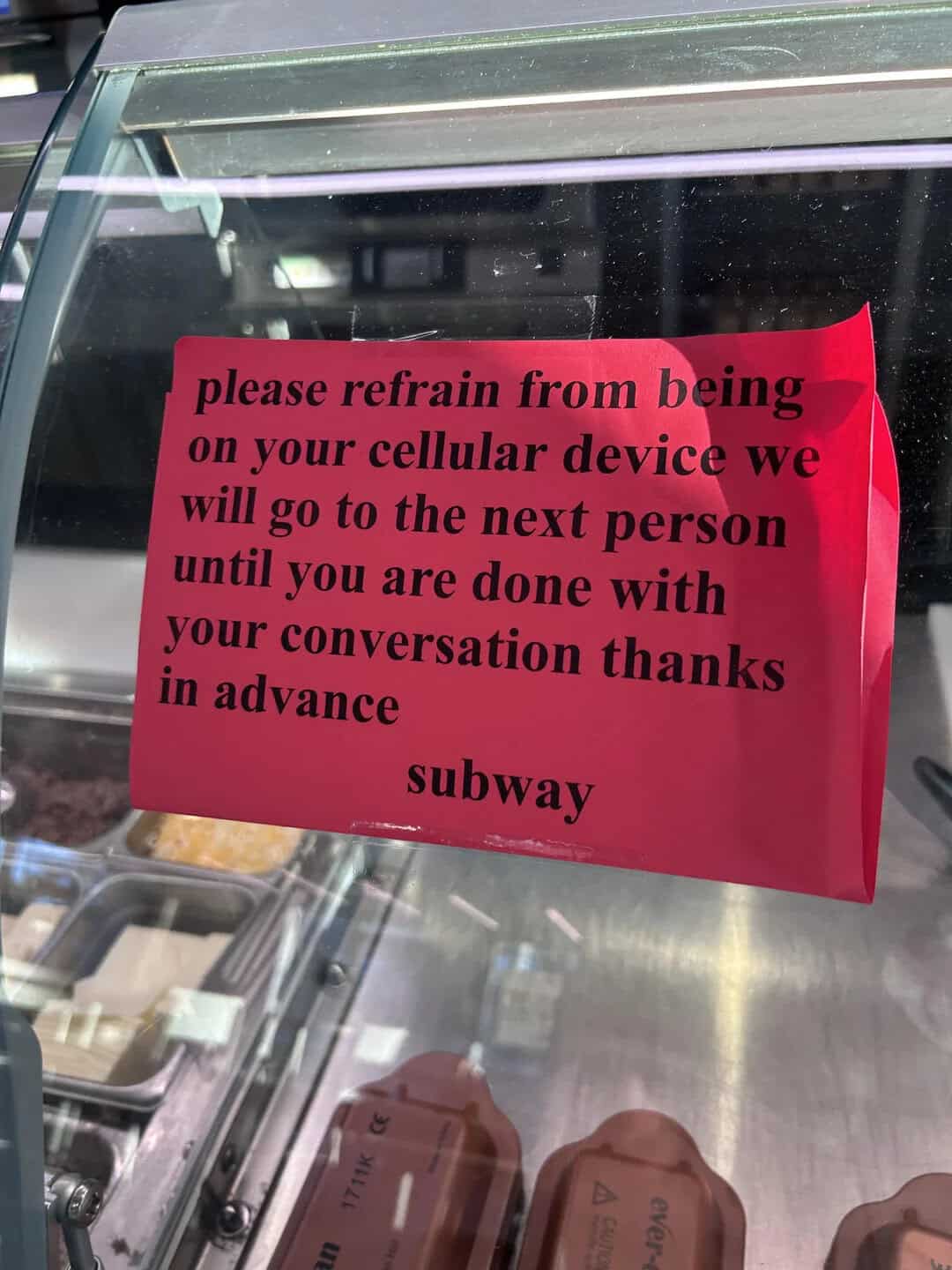 Sign requesting to refrain from using cell phones, signed by Subway.