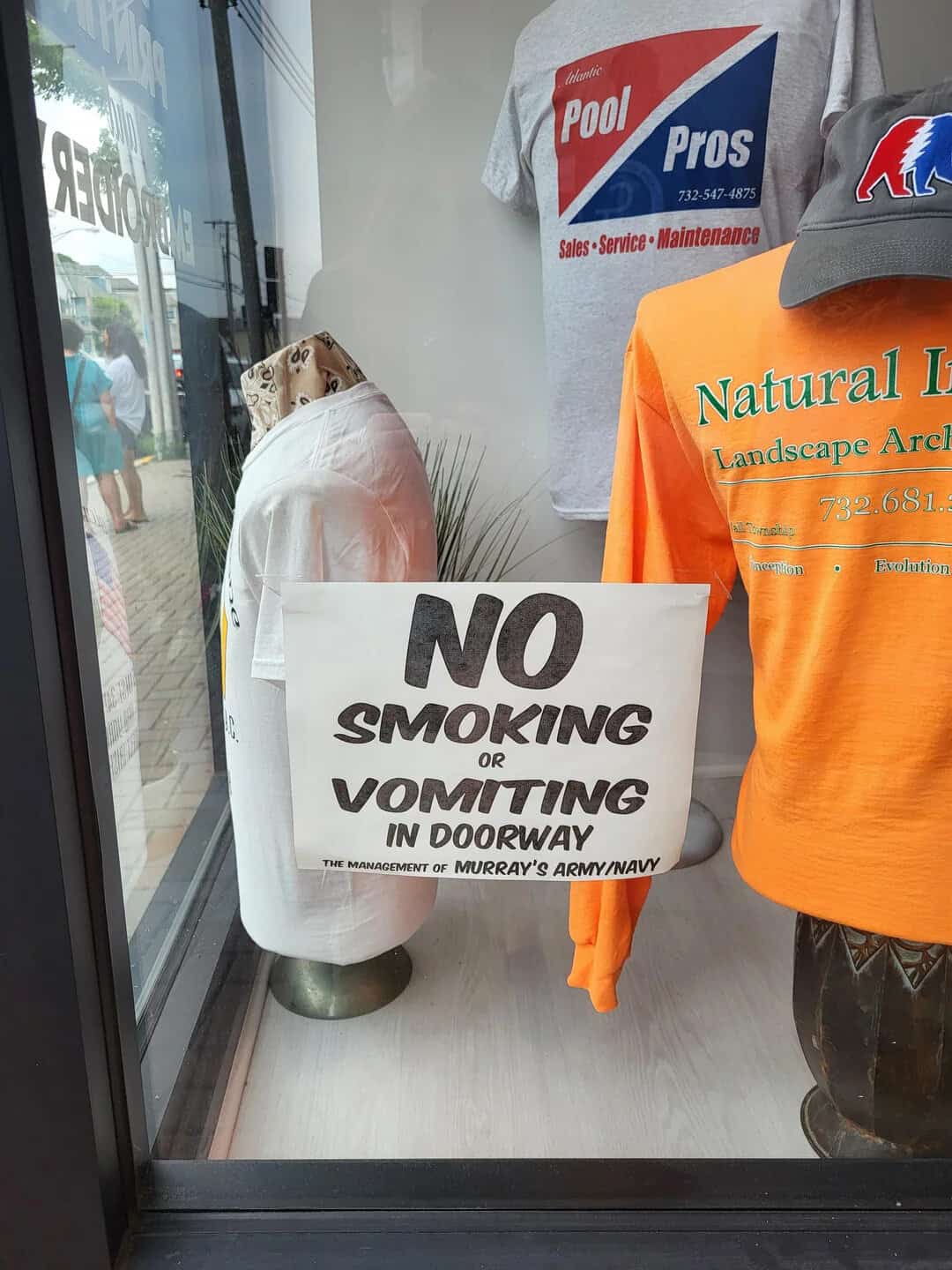 No smoking or vomiting in doorway sign at store entrance.
