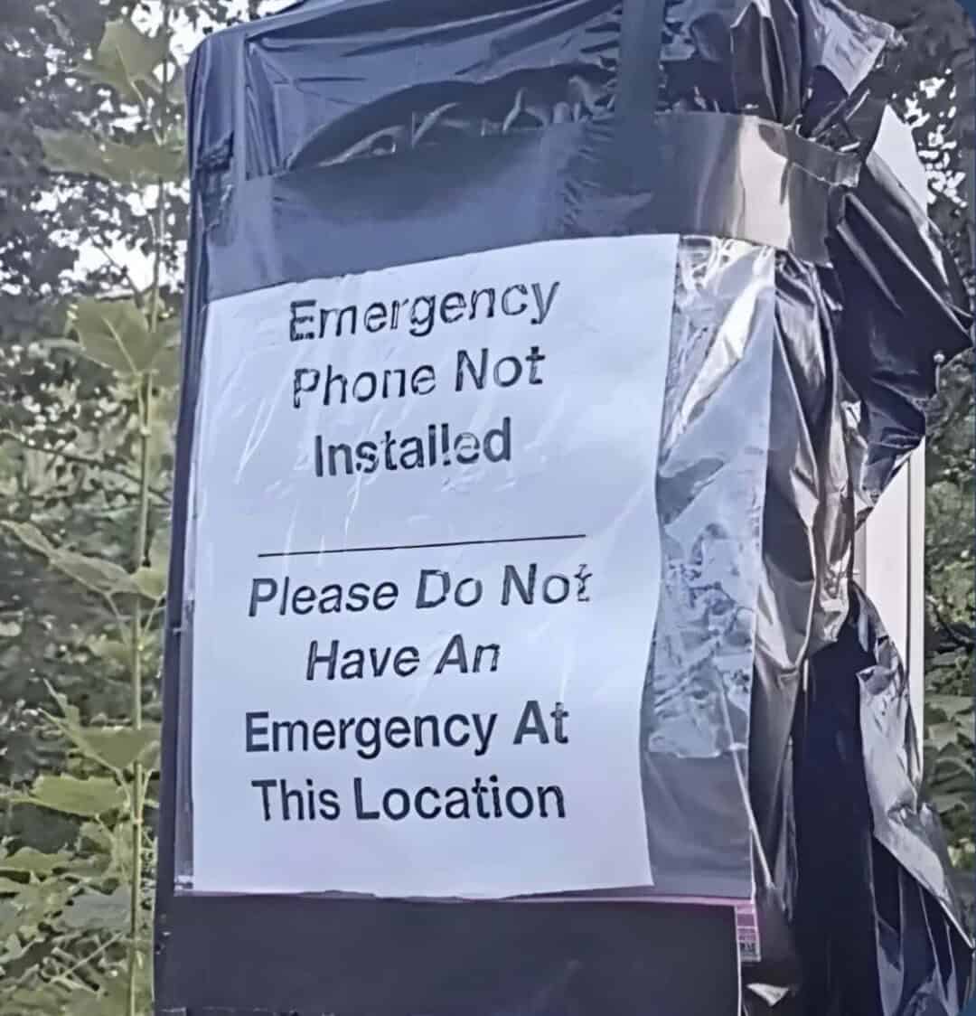 Sign says 'Emergency Phone Not Installed. Please Do Not Have An Emergency At This Location'.