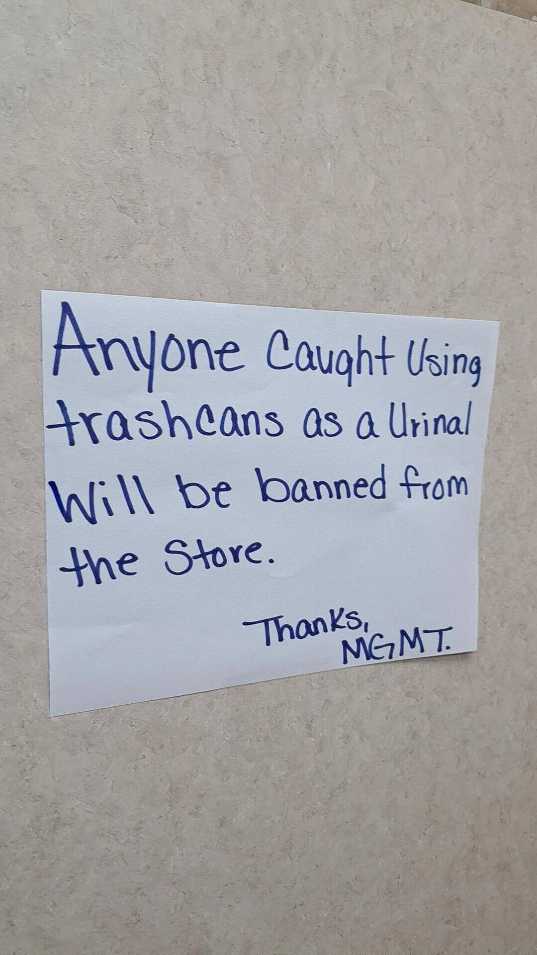 Sign warning against using trash cans as urinals, signed by MGMT.