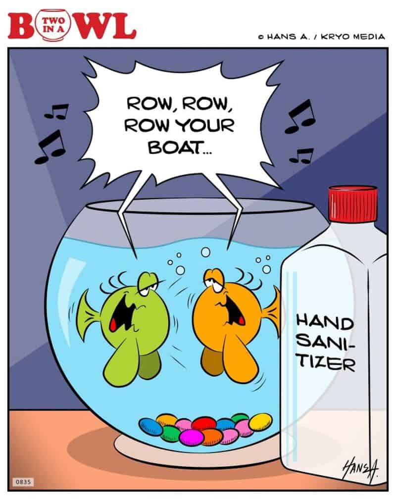 Two fish singing in a bowl, one green and one orange, with a hand sanitizer bottle nearby.