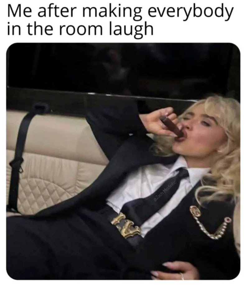 Woman in a suit with blonde hair drinking from a bottle, laughing.