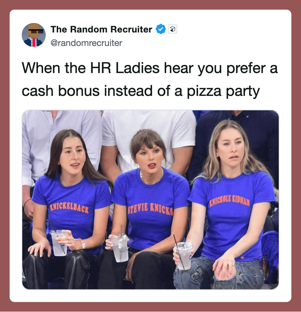 "Three women in blue T-shirts with humorous text, sitting with drinks, reacting to a joke or story.".