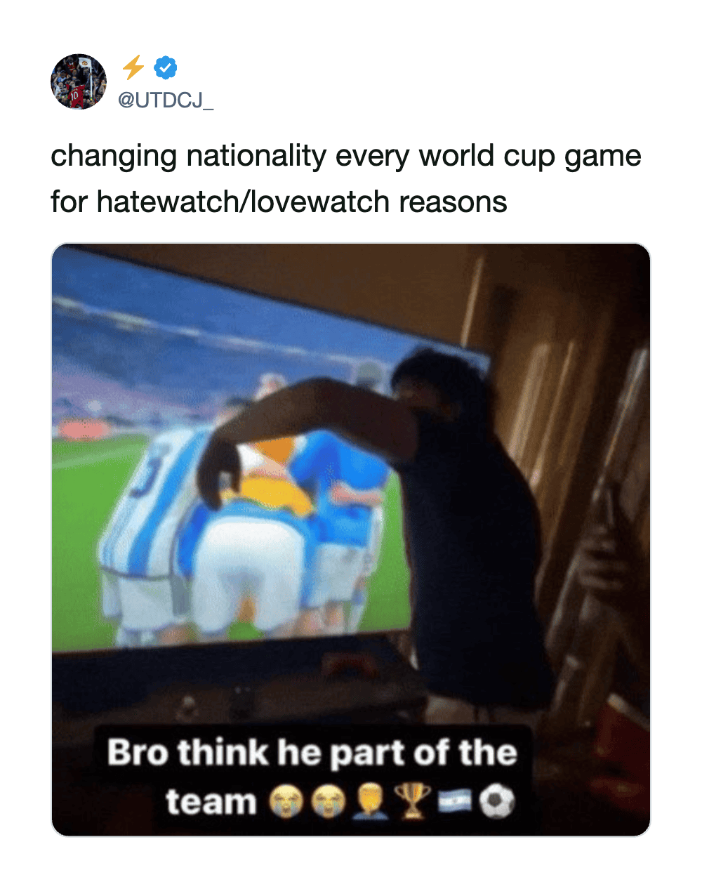 Person changing nationality during a World Cup game, TV showing players in blue and white jerseys.