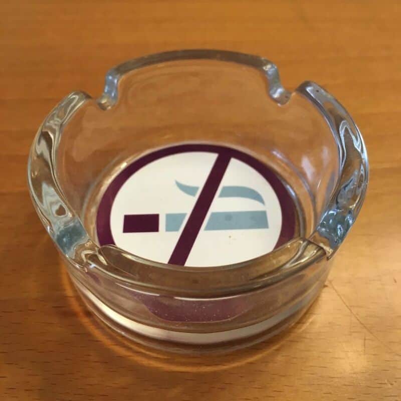 Glass ashtray with a no smoking sign underneath it.