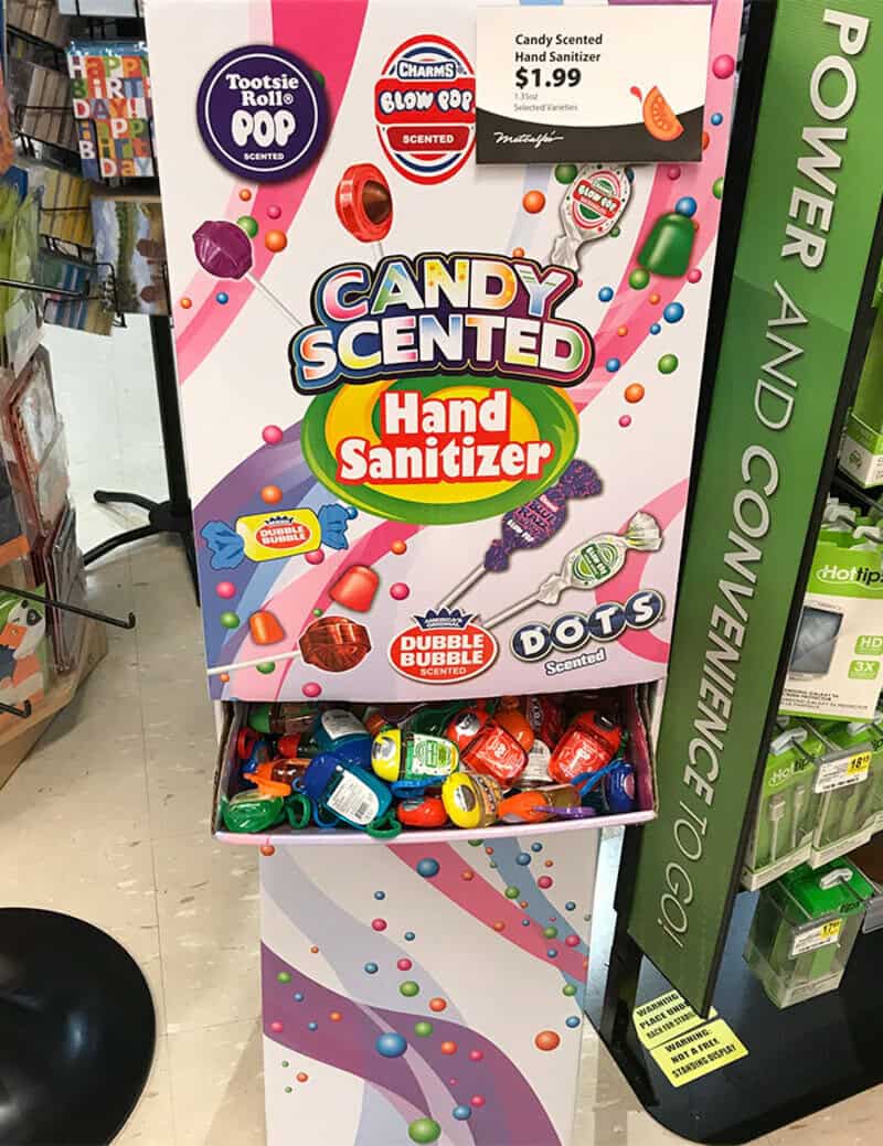 Candy scented hand sanitizer display with colorful candies and a sign.