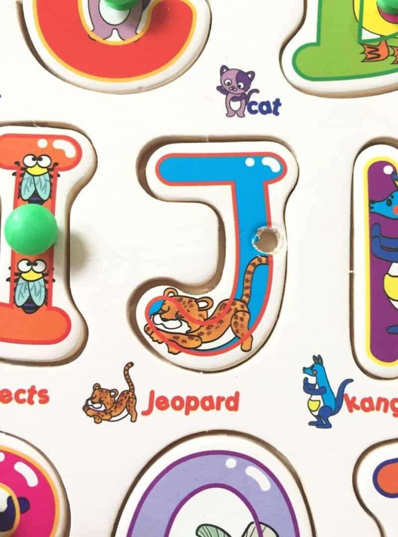 Letter J with a cartoon tiger and a hole in the middle, part of a children's alphabet puzzle.