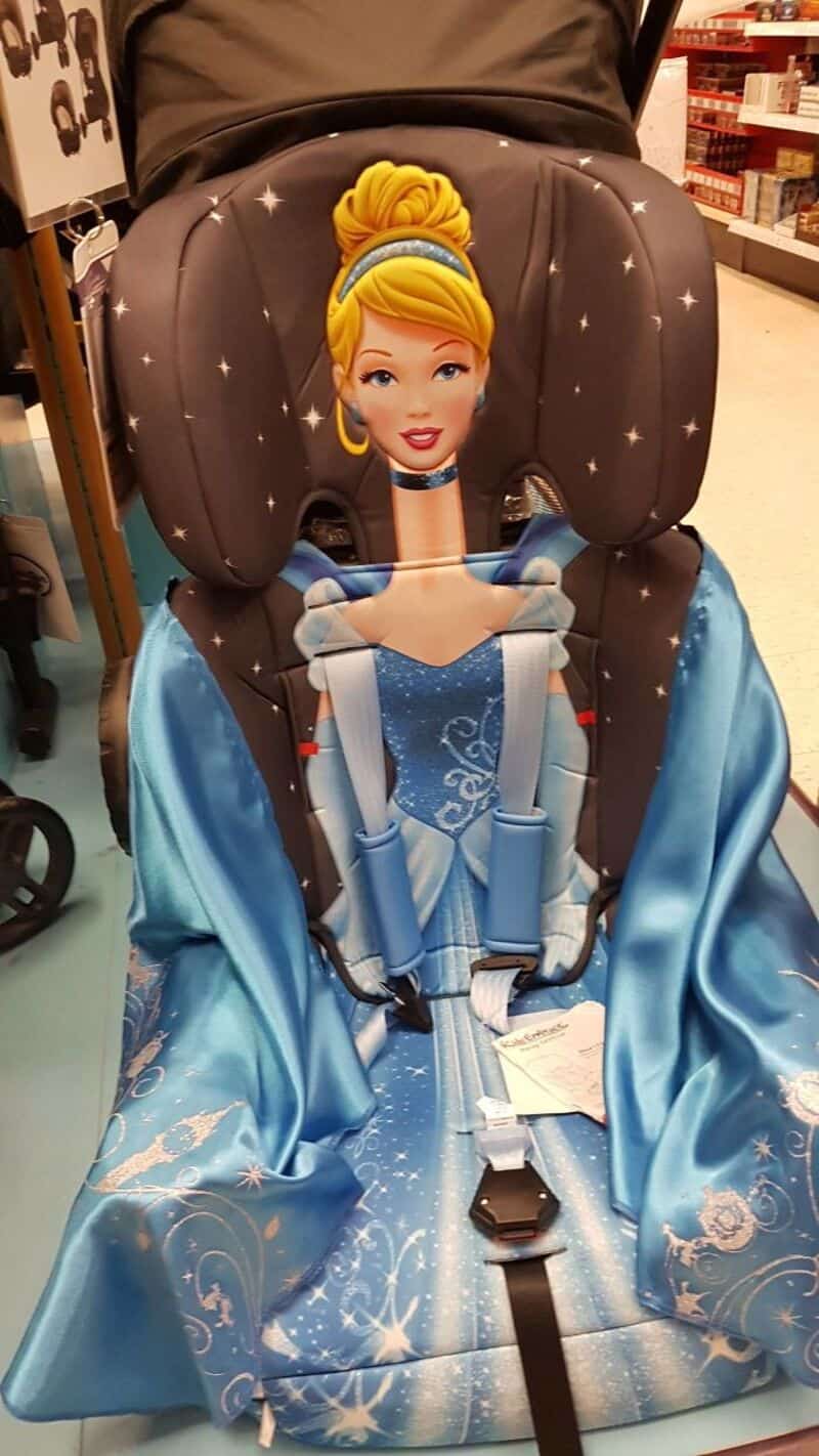 Child's car seat designed as Cinderella with a blue dress and blonde hair in a bun.