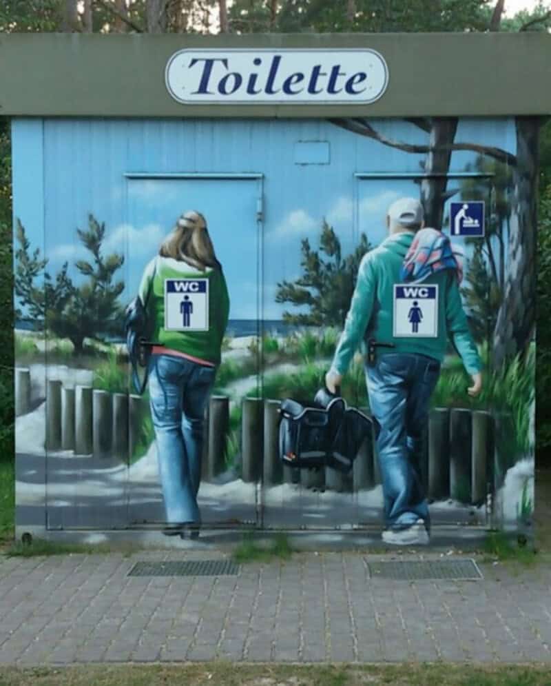Mural of two people walking to a toilet, with a sign above reading 'Toilette'.