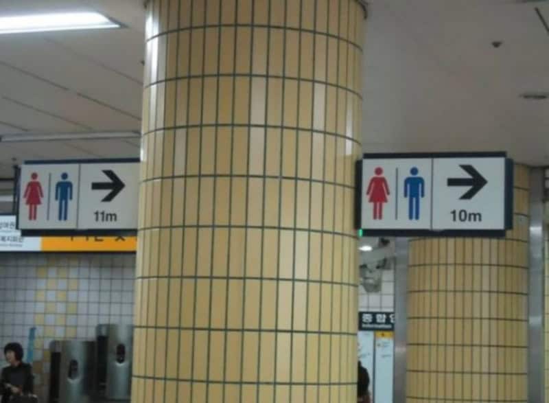 Sign indicating women's and men's restrooms, 10m and 11m away, respectively.