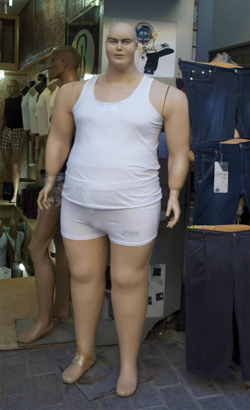 Mannequin in white tank top and shorts in a store display.