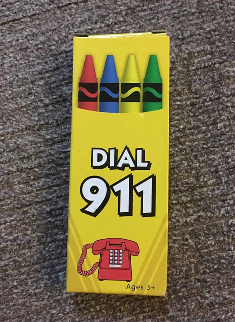 Colorful crayons with a phone and 'Dial 911' text on yellow background.