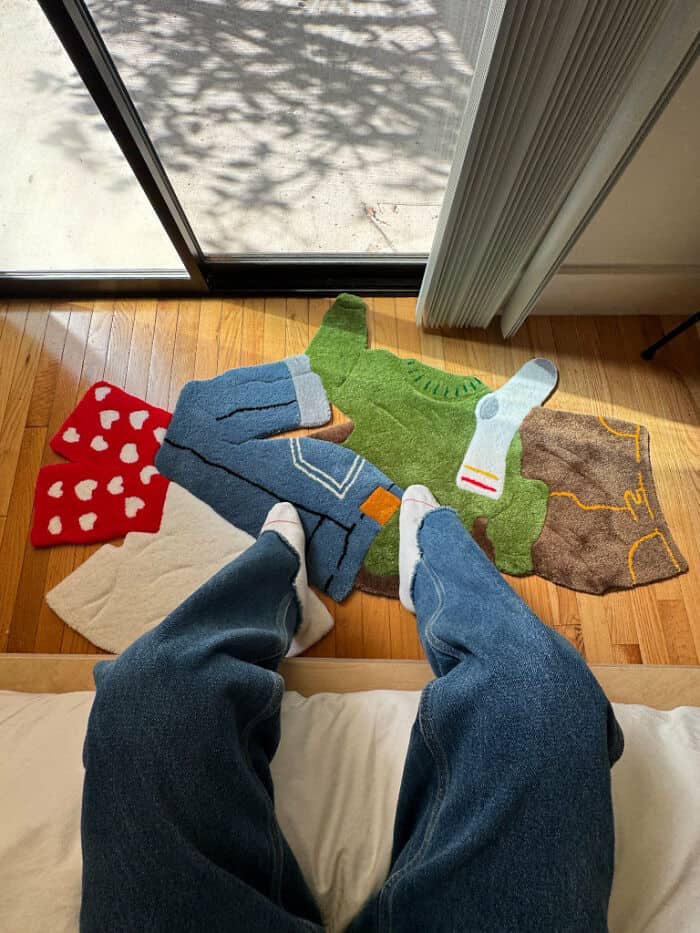 Socks on the floor with various colors and patterns, including red with white hearts, green, blue, w.