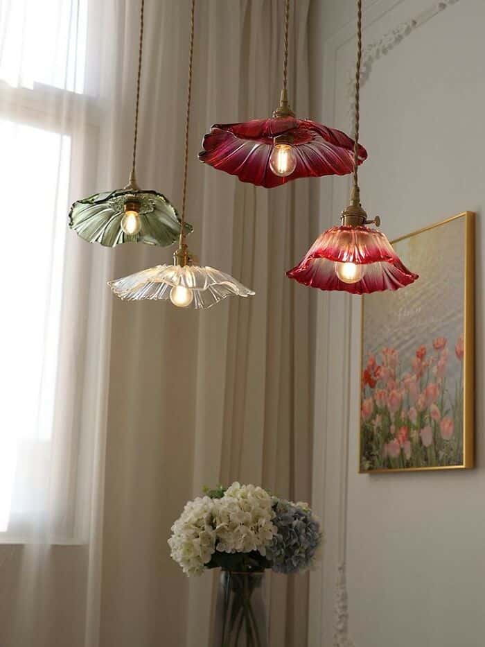 Three pendant lamps with colorful, ruffled glass shades hanging in a room.