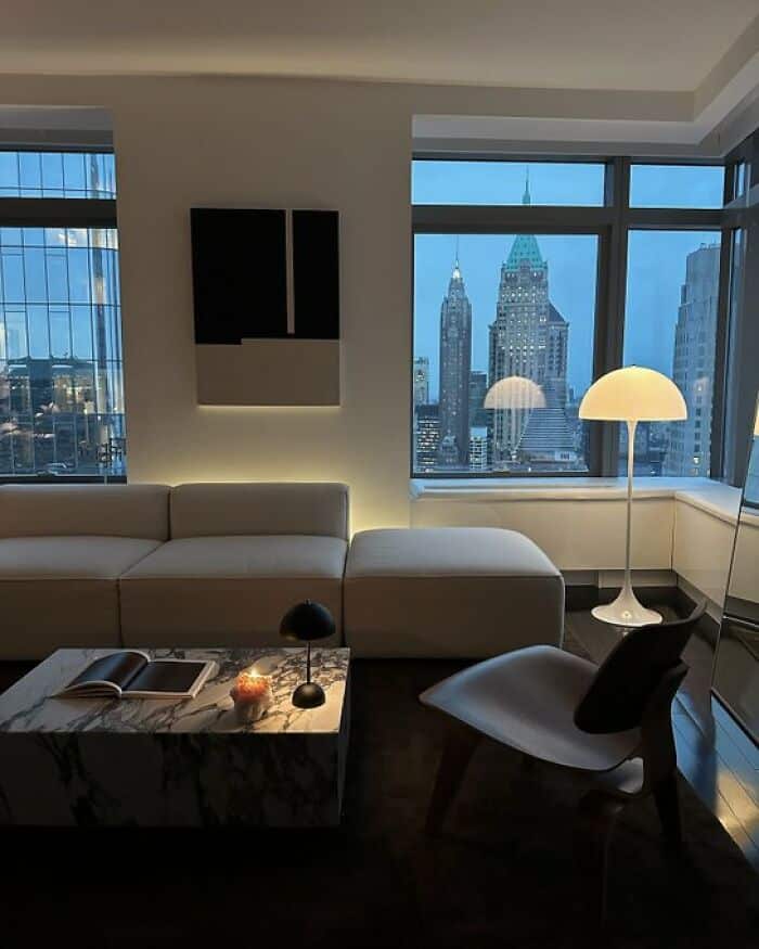 Modern city skyline view from a high-rise apartment window with a cozy interior.